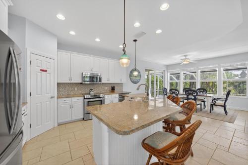a kitchen with white cabinets and a large island at Sea Oats Oasis in Sanibel