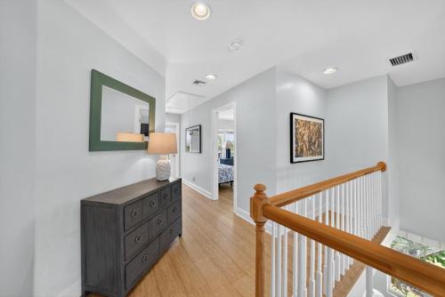 a hallway with a staircase with a dresser and a mirror at Sea Oats Oasis in Sanibel