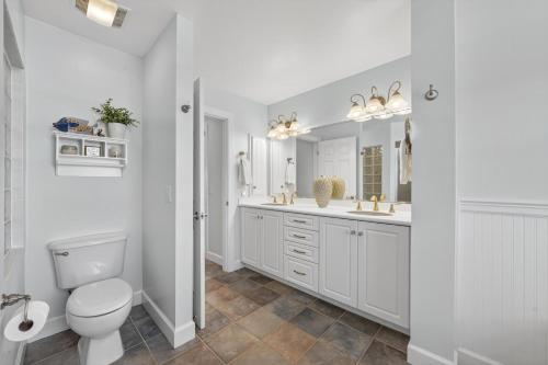 a white bathroom with a toilet and a sink at Sea Oats Oasis in Sanibel