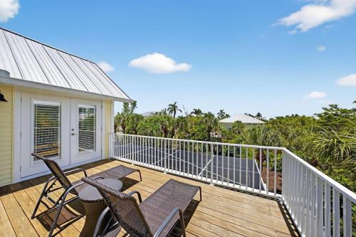a deck with two chairs and a table on it at Sea Oats Oasis in Sanibel