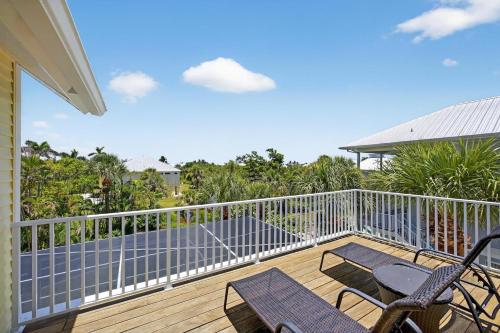 a deck with chairs and tables on a house at Sea Oats Oasis in Sanibel