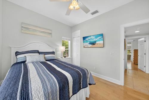 a white bedroom with a bed and a ceiling fan at Sea Oats Oasis in Sanibel