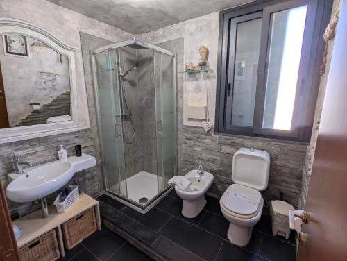 a bathroom with a shower and a toilet and a sink at La Perla Sicula Etna Pool in Agnone Bagni