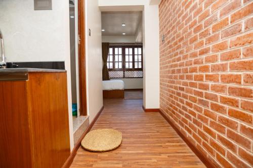 un corridoio con un muro di mattoni e un tappeto sul pavimento di Mandah Heritage Home a Kathmandu
