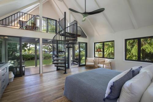 a bedroom with a bed and a spiral staircase at Hui Pu in Waikoloa