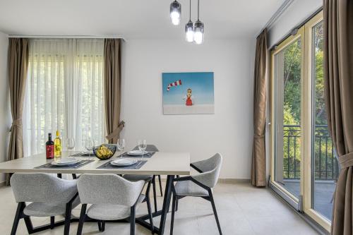a dining room with a white table and chairs at Vertmont Villa in Sveti Stefan