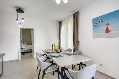 a white dining room with a white table and chairs at Vertmont Villa in Sveti Stefan