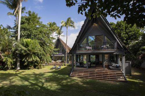 a house with a gambrel roof with a porch at Hui Pu in Waikoloa