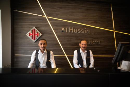 two men sitting at a desk in front of a houston sign at فندق الحسين السياحي in Asyut
