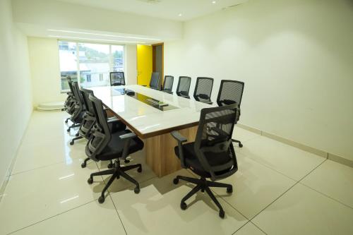 a conference room with a long table and chairs at Royal Plaza Suites by RAK Rooms, Mangaluru in Mangalore