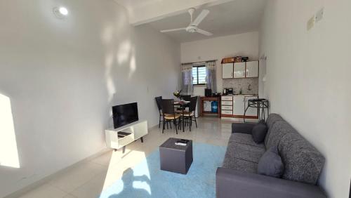 a living room with a couch and a kitchen at JG&A Home in Itauguá
