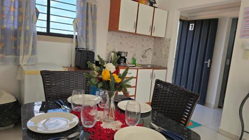 a dining room table with a vase of flowers on it at JG&A Home in Itauguá