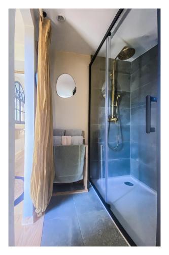 La salle de bains est pourvue d'une douche et d'une cabine de douche en verre. dans l'établissement Casita Alegria & Cabana Alegria - 2 chambres d'hôtes, à Plassac