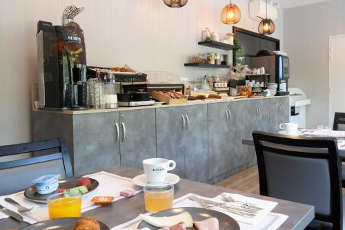 a kitchen with a table with food on it at Logis Hôtel l'Amandier in Morlaas
