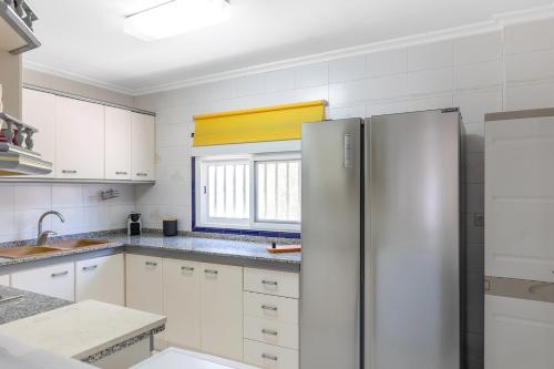 a kitchen with white cabinets and a stainless steel refrigerator at Finca Pozoblanco with private pool 
