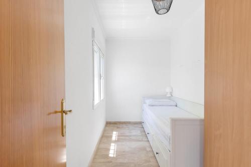 a white bathroom with a door and a window at Finca Pozoblanco with private pool 