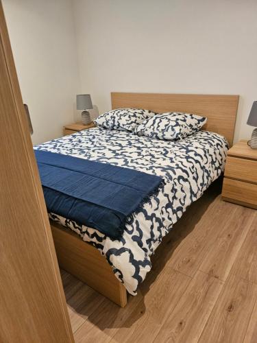 a bedroom with a bed with a blue and white comforter at Grande Sologne in Clémont