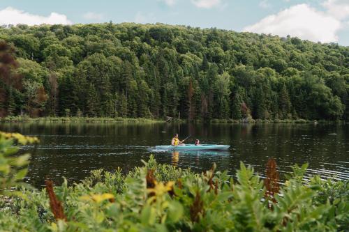 a person in a boat on a lake at Huttopia Les Deux Lacs - Laurentides in Mont-Blanc