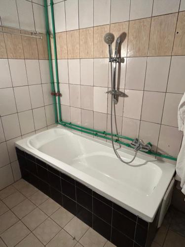 a bath tub with a shower in a bathroom at Prodiges Hôtel in Yaoundé