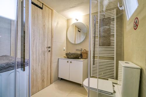 a bathroom with a toilet and a sink and a mirror at Faytale Apartment Nafplio in Ária
