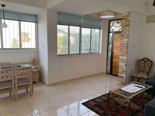 a living room with a bed and some windows at Quiet and Spacious Luxury Apartment with Splendid View between Carmel and Downtown in Haifa