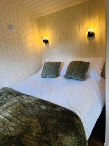 a bedroom with a white bed with two pillows at Hut in the hall in Bedale