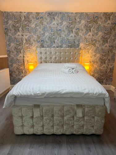 a bedroom with a large bed with a tufted headboard at Full Home with Free Parking in Moss Bank, Crumpsall, Manchester in Manchester