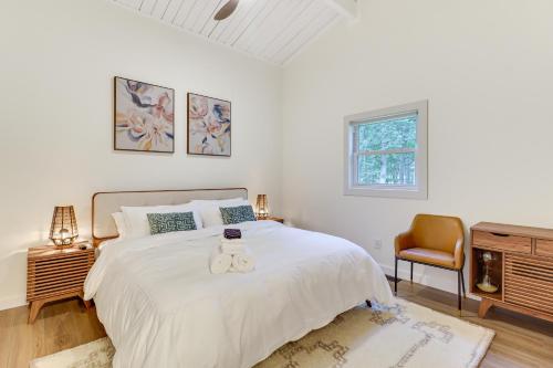 una camera da letto con un grande letto bianco e una sedia di Pool and Lake Access, Yard Poconos Family Getaway a East Stroudsburg