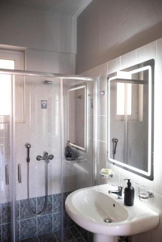 a white bathroom with a sink and a shower at Drosia Apartments in Lefkandi in Lefkandi Chalkidas