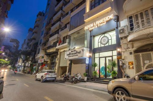 a city street with cars parked in front of buildings at Azen Lakeside Hotel & Travel in Hanoi