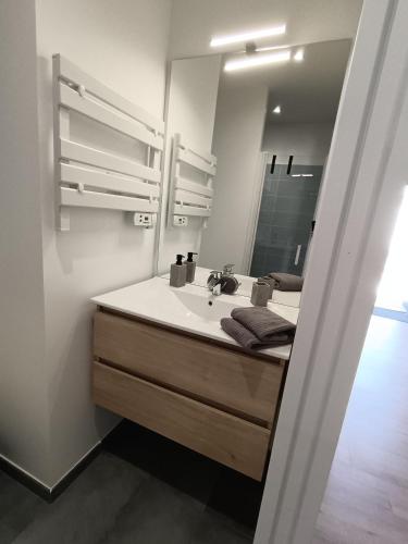 une salle de bain avec un lavabo et un miroir dans l'établissement Le Logis de Raphabel, à Saint-Palais-sur-Mer