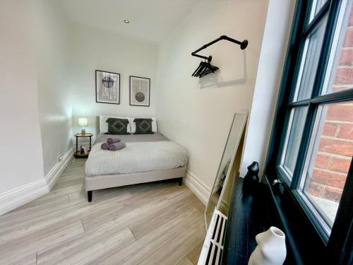 a small bedroom with a bed and a window at Modern 1-Bedroom Apartments near Shoreditch, Old Street & Hoxton by NourNest Apartments in London