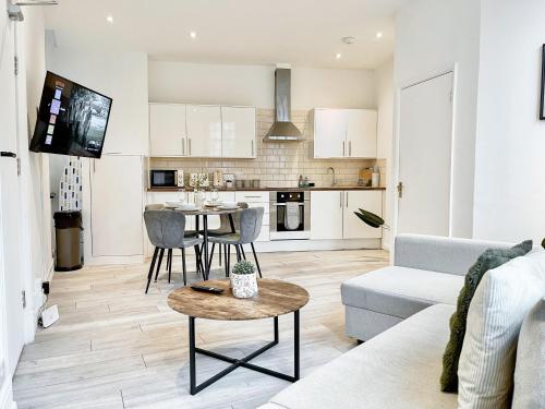 a living room and kitchen with a couch and a table at Modern 1-Bedroom Apartments near Shoreditch, Old Street & Hoxton by NourNest Apartments in London