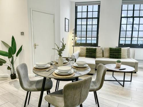 a living room with a table and chairs and a couch at Modern 1-Bedroom Apartments near Shoreditch, Old Street & Hoxton by NourNest Apartments in London
