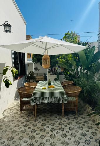 a table with a white umbrella on a patio at Casa Sasa in Porto Cesareo