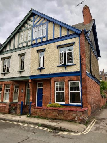 a brick house with a blue door on a street at Vas' York House in York
