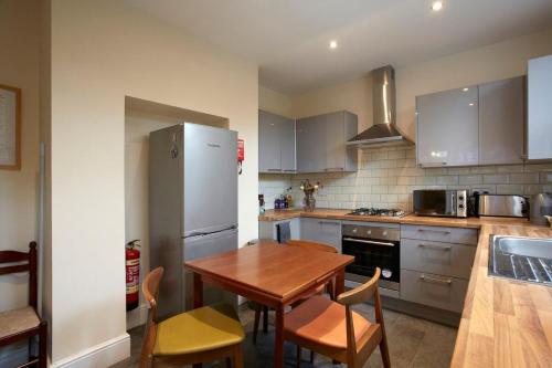 a kitchen with a wooden table and a refrigerator at Vas' York House in York