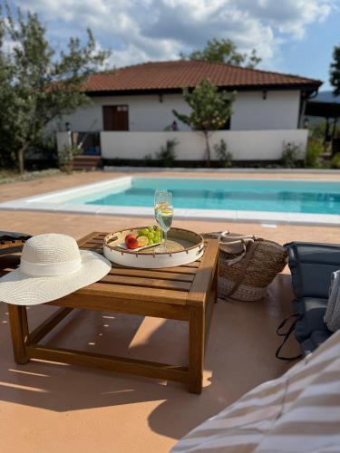 a table with a plate of fruit and a glass of wine at House Milovanovic in Soko Banja