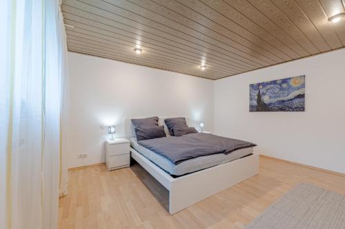 a bedroom with a bed in a white room at Ferienwohnung am Feld Winterbach in Sankt Wendel
