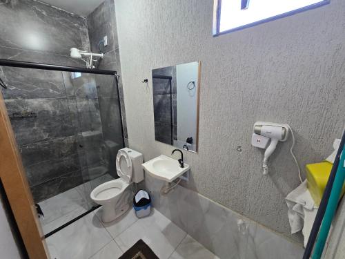a bathroom with a shower and a toilet and a sink at Flat completo a 22 minutos do polo industrial in Aparecida de Goiania