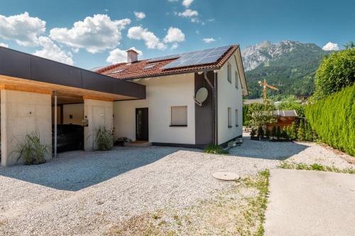 a white house with a red roof and a driveway at Appartement Kammblick in Gröbming