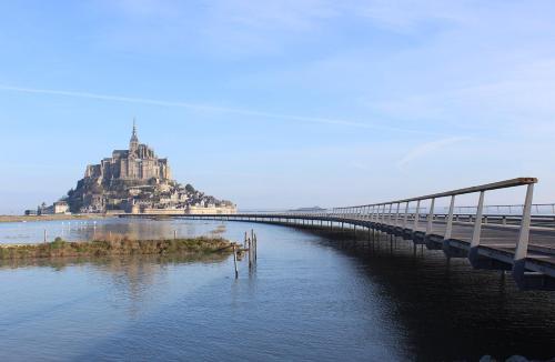 a bridge over the water with an island in the distance at Cosy rental - Normandy in Sourdeval