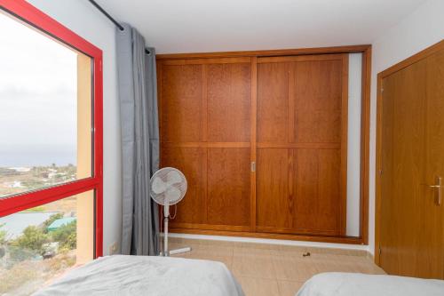 1 dormitorio con armario grande y ventana en 2BR BuenaVida Residential, en Breña Baja