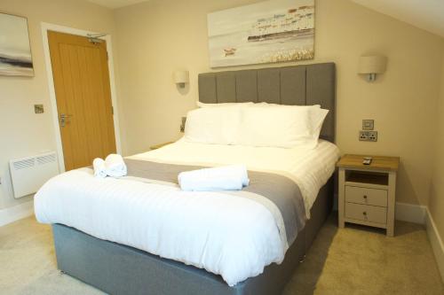 a bedroom with a large bed with two towels on it at The Barmouth Bar & Grill in Barmouth