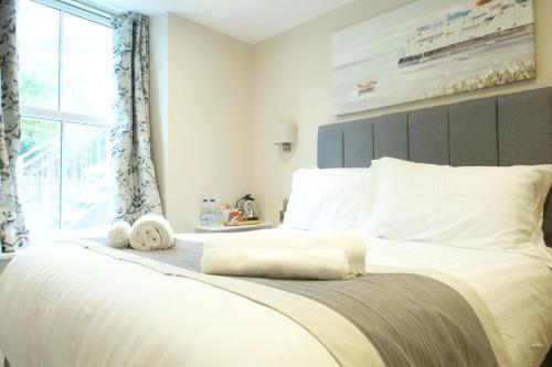 a bedroom with a large white bed with a large window at The Barmouth Bar & Grill in Barmouth