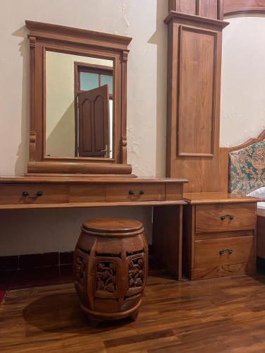 a wooden vanity with a mirror and a wooden stool at Harmadha Villa in Sarangan