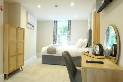 a bedroom with a bed and a desk with a dresser at The Barmouth Bar & Grill in Barmouth