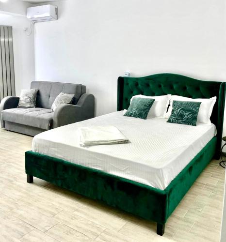 a green bed and a couch in a room at Nik and dom Alezzi studio in Mamaia Sat/Năvodari