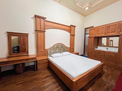 a bedroom with a bed and a tv in it at Harmadha Villa in Sarangan