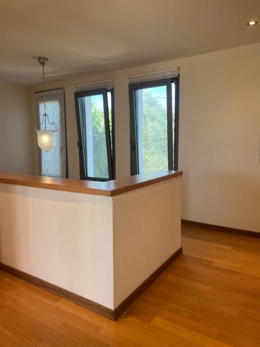 an empty room with a counter and three windows at Ira Private Villa with Pool in Tragaki